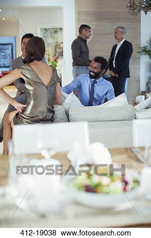 Stock Photo - Friends relaxing together at party. Fotosearch