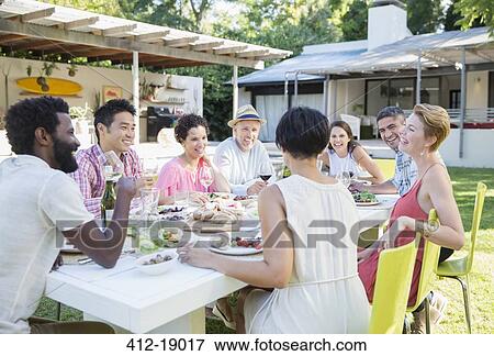 Friends talking at dinner party View Large Photo Image Stock Photo - Friends talking at dinner party. Fotosearch