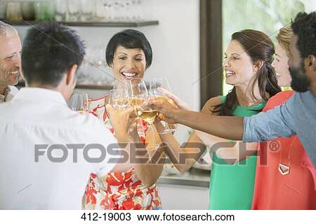 Friends toasting each other at party View Large Photo Image Stock Image - Friends toasting each other at party. Fotosearch