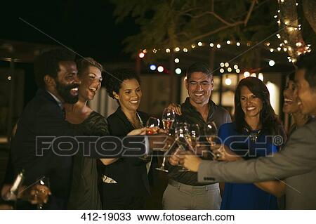 Friends toasting each other at party View Large Photo Image Stock Image - Friends toasting each other at party. Fotosearch