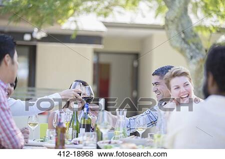 Friends toasting each other at party View Large Photo Image Stock Photo - Friends toasting each other at party. Fotosearch