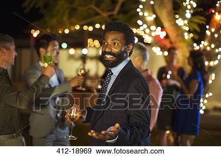 Man gesturing with wine at party View Large Photo Image Stock Photo - Man gesturing with wine at party. Fotosearch
