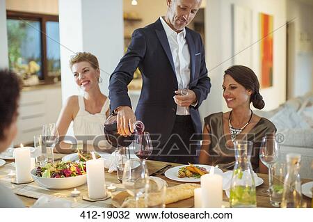 Man pouring wine at dinner party View Large Photo Image Stock Image - Man pouring wine at dinner party. Fotosearch