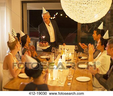 Man serving birthday cake at party View Large Photo Image Stock Image - Man serving birthday cake at party. Fotosearch