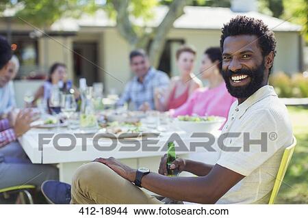 Man smiling at table outdoors View Large Photo Image Picture - Man smiling at table outdoors. Fotosearch