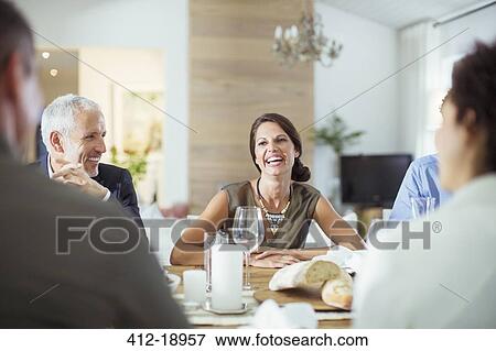 Stock Photo - People talking at dinner party. Fotosearch