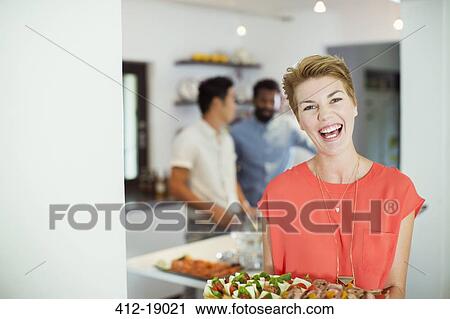 Woman carrying tray of food at party View Large Photo Image Stock Image - Woman carrying tray of food at party. Fotosearch
