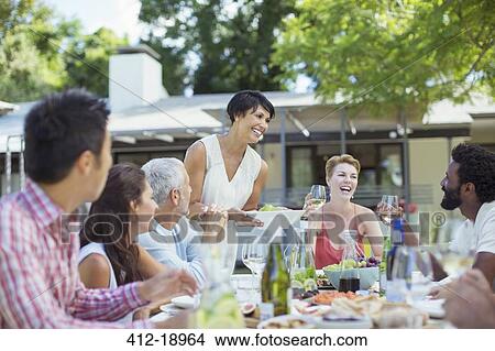 Picture - Woman serving friends at party. Fotosearch