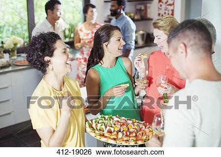 Woman serving friends at party View Large Photo Image Stock Photograph - Woman serving friends at party. Fotosearch