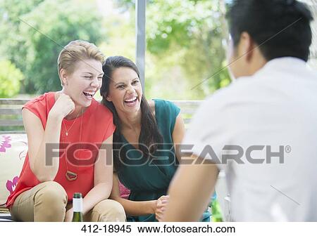 Stock Photography - Women laughing at party. Fotosearch