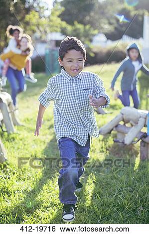 Boy walking in grass outdoors View Large Photo Image Stock Photograph - Boy walking in grass outdoors. Fotosearch