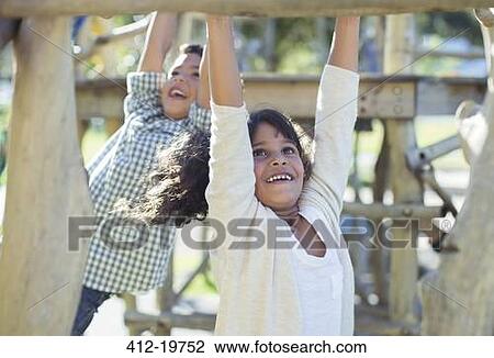 Stock Image - Children climbing on monkey bars. Fotosearch