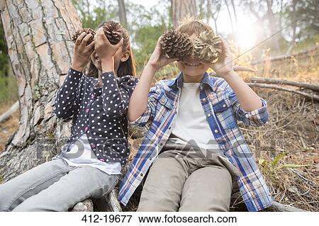 Children playing with pine cones in forest View Large Photo Image Stock Photo - Children playing with pine cones in forest. Fotosearch