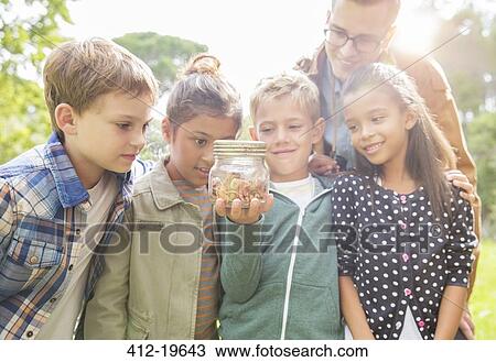 Student and teacher examining insects in jar outdoors View Large Photo Image Stock Image - Student and teacher examining insects in jar outdoors. Fotosearch