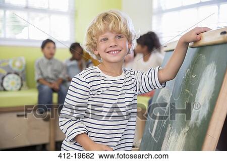 Student drawing on chalkboard in classroom View Large Photo Image Stock Image - Student drawing on chalkboard in classroom. Fotosearch