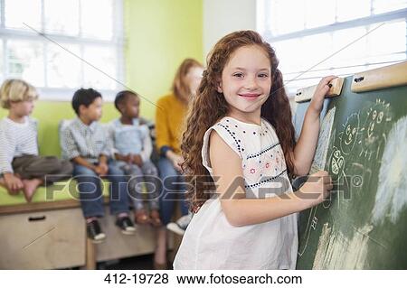 Student drawing on chalkboard in classroom View Large Photo Image Stock Photo - Student drawing on chalkboard in classroom. Fotosearch