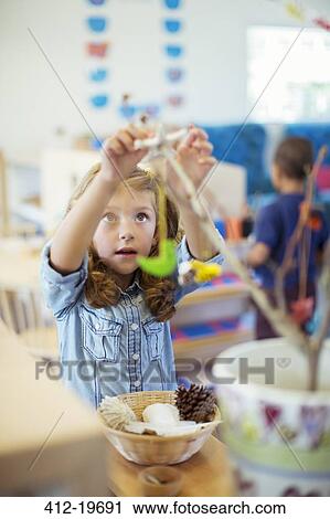 Stock Image - Student playing with model in classroom. Fotosearch