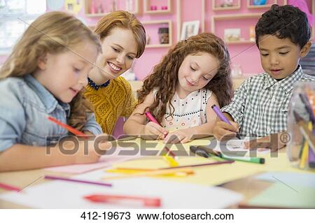 Stock Image - Students and teacher drawing in classroom. Fotosearch