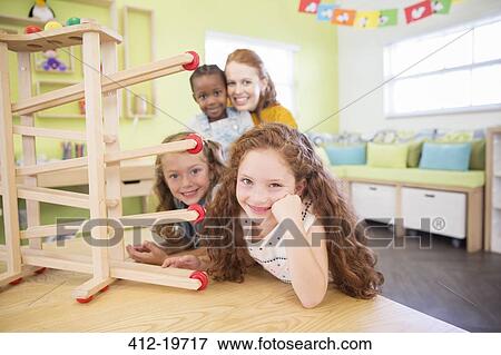 Stock Photo - Students and teacher using model in classroom. Fotosearch