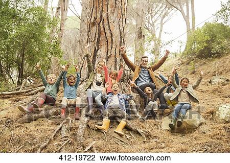 Stock Image - Students and teachers cheering in forest. Fotosearch