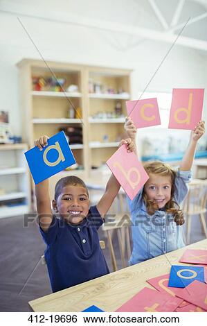 Students holding letters in classroom View Large Photo Image Stock Photograph - Students holding letters in classroom. Fotosearch