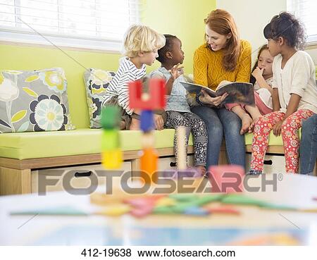 Stock Photo - Teacher and students reading in classroom. Fotosearch