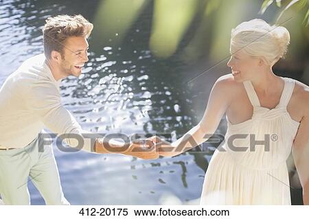 Couple holding hands by pool outdoors View Large Photo Image Stock Photography - Couple holding hands by pool outdoors. Fotosearch