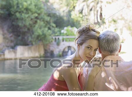 Stock Photo - Couple overlooking river and bridge. Fotosearch