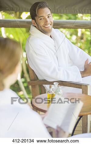 Picture - Couple relaxing together in bathrobes. Fotosearch