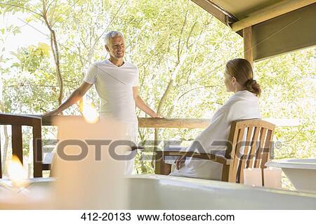 Couple talking on rustic balcony View Large Photo Image Stock Image - Couple talking on rustic balcony. Fotosearch