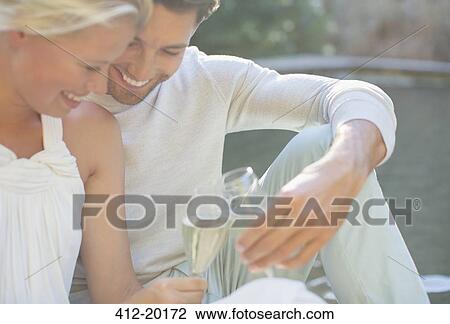 Couple toasting each other with champagne outdoors View Large Photo Image Stock Image - Couple toasting each other with champagne outdoors. Fotosearch