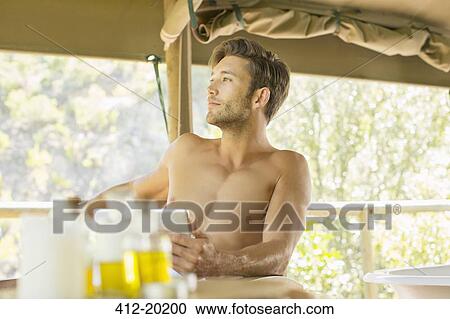 Stock Image - Man using digital tablet at table. Fotosearch