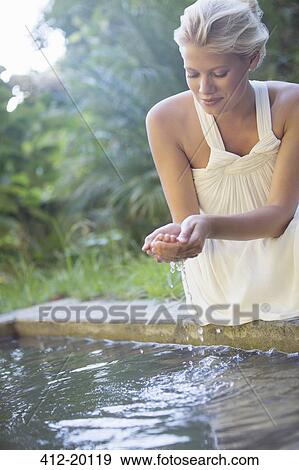 Woman cupping pool water in her hand View Large Photo Image Stock Photo - Woman cupping pool water in her hand. Fotosearch
