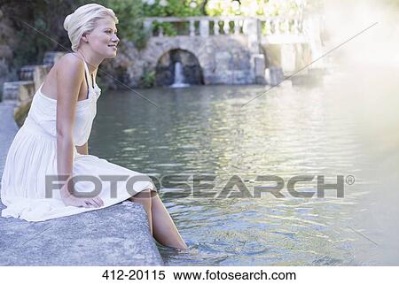 Stock Photography - Woman dangling feet in pool. Fotosearch