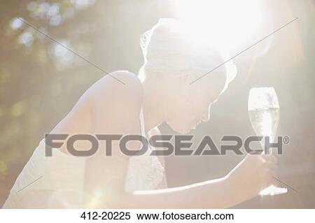 Stock Photography - Woman drinking champagne outdoors. Fotosearch