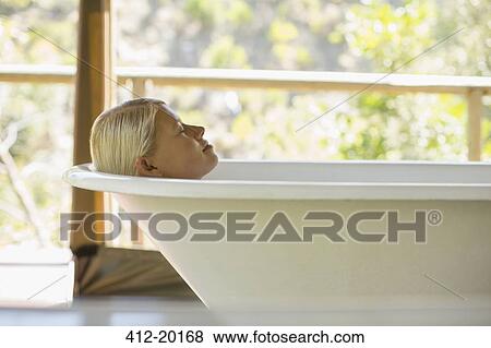 Woman relaxing in bathtub View Large Photo Image Stock Photo - Woman relaxing in bathtub. Fotosearch