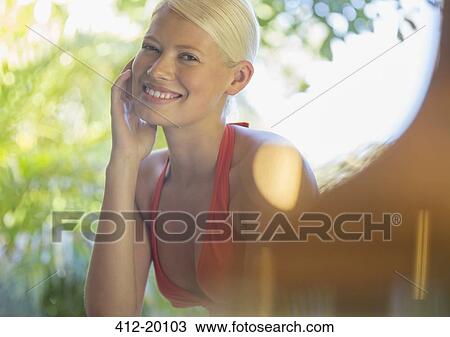 Stock Image - Woman resting chin in hand outdoors. Fotosearch