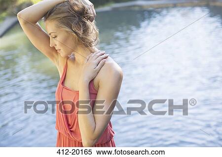 Woman standing by pond View Large Photo Image Stock Photography - Woman standing by pond. Fotosearch