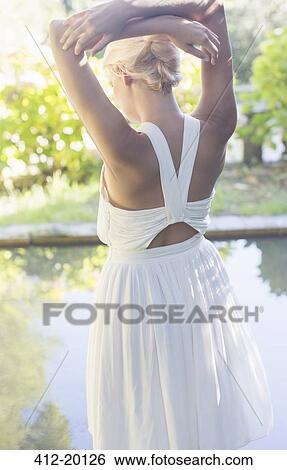 Stock Photograph - Woman standing by pool outdoors. Fotosearch