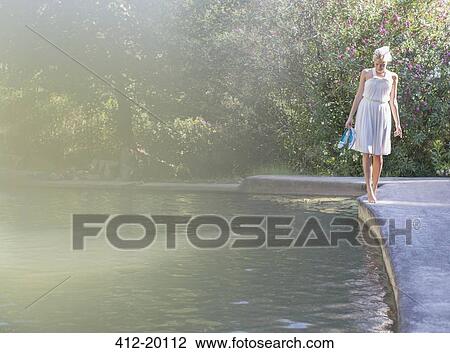 Woman walking by edge of pool View Large Photo Image Stock Image - Woman walking by edge of pool. Fotosearch