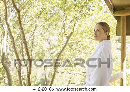Stock Photography - Woman wearing bathrobe on balcony. Fotosearch