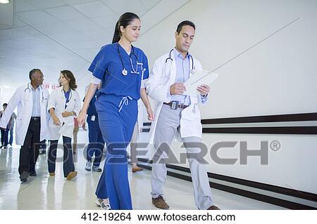 Doctor and nurse reading medical chart in hospital View Large Photo Image Picture - Doctor and nurse reading medical chart in hospital. Fotosearch