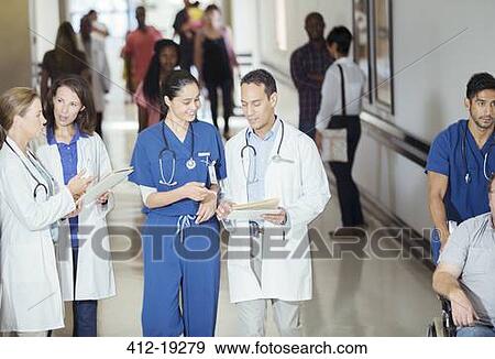 Doctor and nurse reading medical chart in hospital hallway View Large Photo Image Stock Photo - Doctor and nurse reading medical chart in hospital hallway. Fotosearch