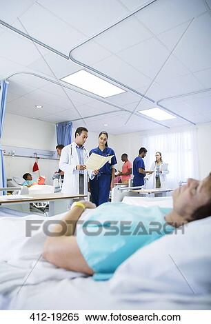 Doctor and nurse reading medical chart in hospital room View Large Photo Image Stock Photography - Doctor and nurse reading medical chart in hospital room. Fotosearch