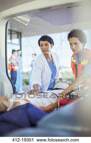 Doctor and paramedic examining patient in ambulance View Large Photo Image Stock Image - Doctor and paramedic examining patient in ambulance. Fotosearch