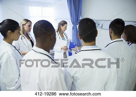 Doctor and residents examining patient in hospital room View Large Photo Image Stock Photograph - Doctor and residents examining patient in hospital room. Fotosearch