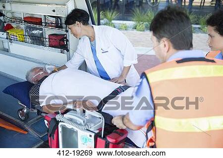 Stock Photo - Doctor examining patient on ambulance stretcher. Fotosearch