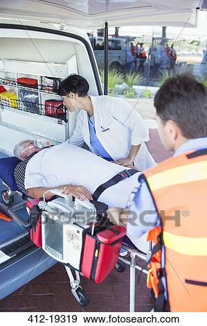 Doctor examining patient on ambulance stretcher View Large Photo Image Stock Photo - Doctor examining patient on ambulance stretcher. Fotosearch