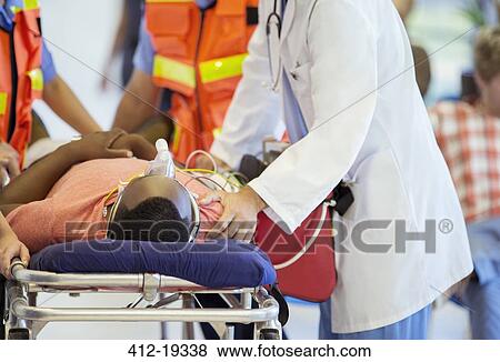 Doctor examining patient on stretcher View Large Photo Image Stock Photo - Doctor examining patient on stretcher. Fotosearch