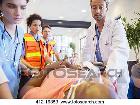 Doctor, nurses and paramedics examining patient in hospital View Large Photo Image Stock Image - Doctor, nurses and paramedics examining patient in hospital. Fotosearch